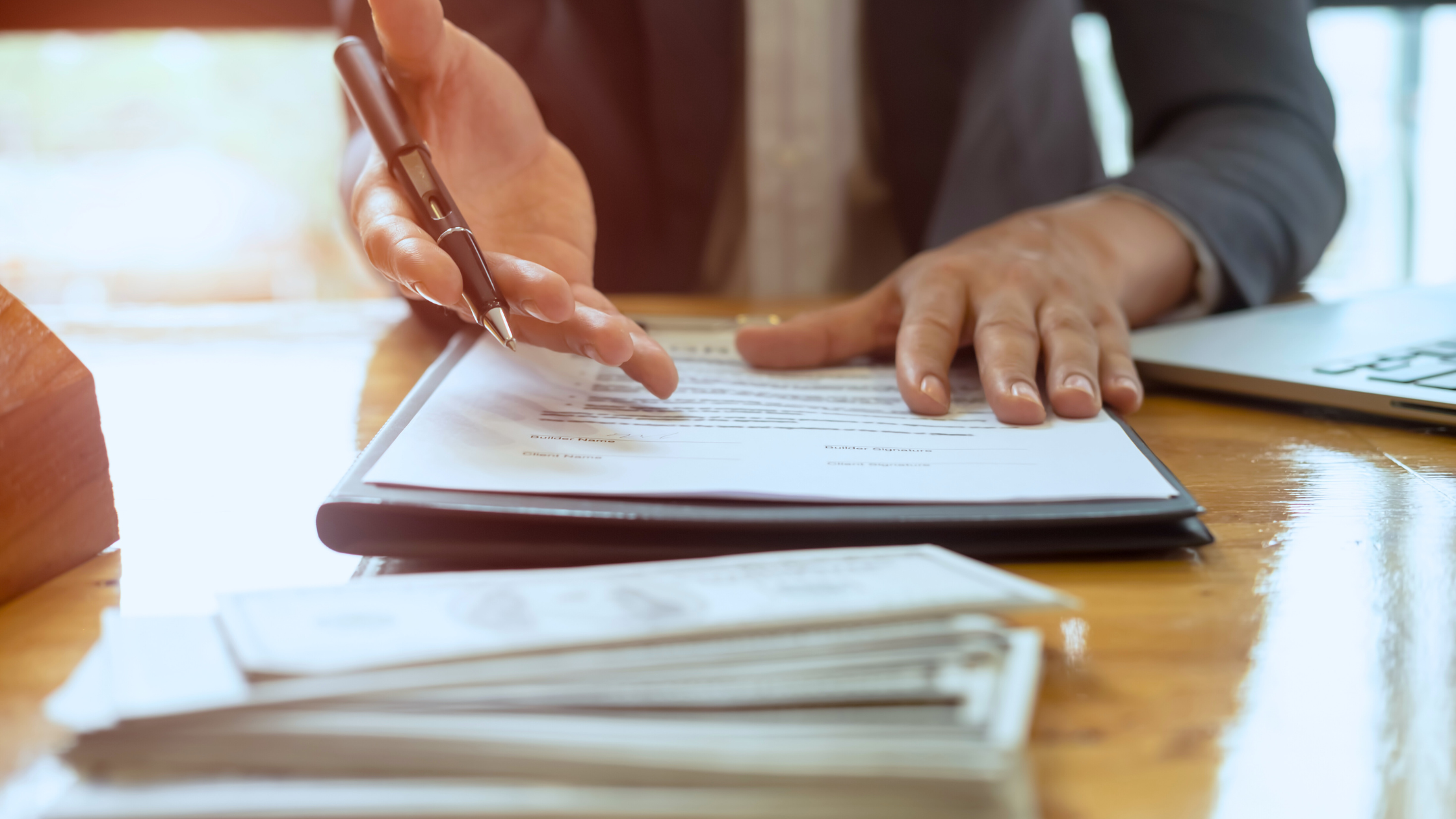 a person's hands holding a pen over a legal document
