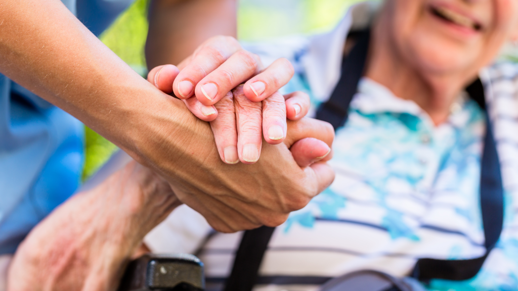 close up of clasped hands of an older white person and a younger white person